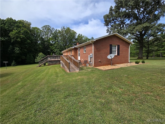 rear view of property featuring a yard and a wooden deck