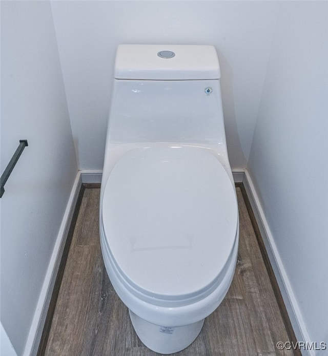 interior details featuring wood-type flooring and toilet