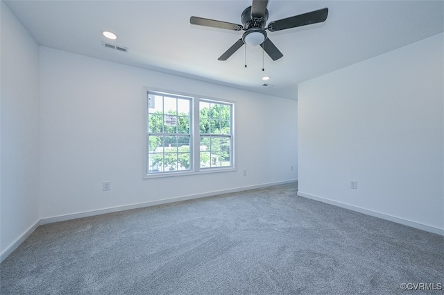 carpeted spare room with ceiling fan