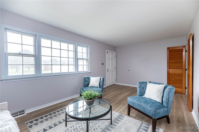 sitting room with wood finished floors, baseboards, and visible vents