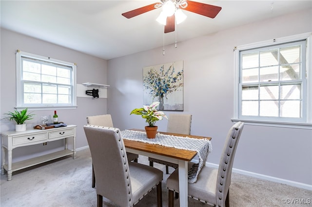 dining area with light carpet, ceiling fan, and baseboards