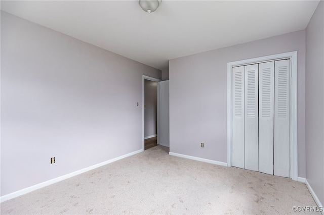 unfurnished bedroom featuring a closet, baseboards, and carpet floors