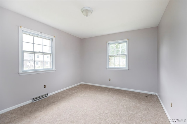 spare room with visible vents, baseboards, and carpet