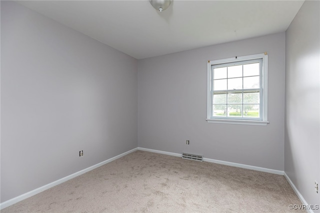 carpeted empty room featuring baseboards and visible vents