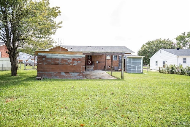 back of house featuring brick siding, a patio, a yard, and fence