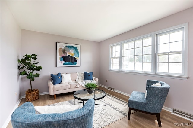 living area featuring wood finished floors, visible vents, and baseboards