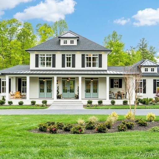 rear view of property featuring a standing seam roof, french doors, and covered porch