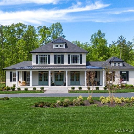 view of front of home with a standing seam roof, covered porch, french doors, and a front lawn