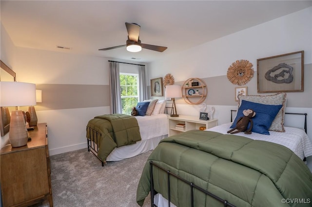 carpeted bedroom featuring baseboards, visible vents, and ceiling fan