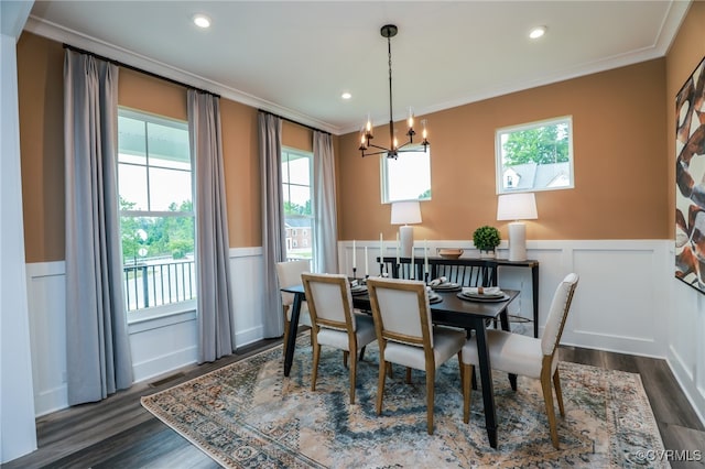 dining space featuring ornamental molding, dark wood-type flooring, and an inviting chandelier