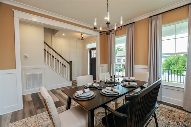 dining room featuring hardwood / wood-style flooring, an inviting chandelier, and crown molding