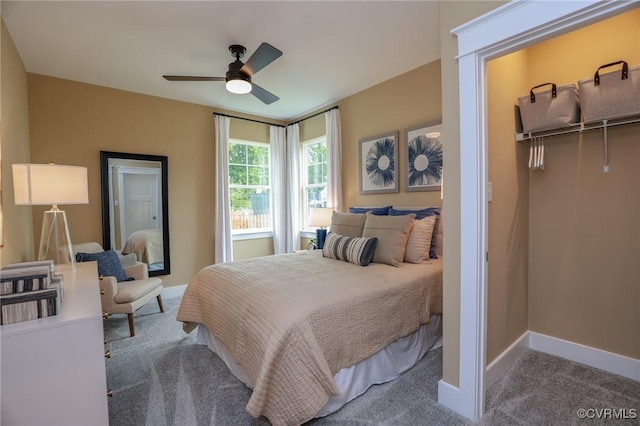 carpeted bedroom with a closet, baseboards, ceiling fan, and a spacious closet