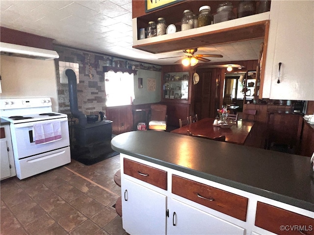 kitchen with a wood stove, white range with electric stovetop, and ceiling fan