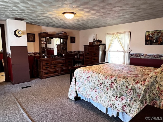 bedroom with a textured ceiling and carpet