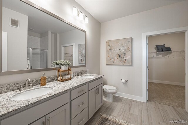 bathroom featuring vanity, toilet, and a shower with door