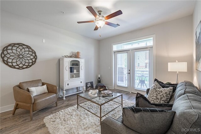 living room featuring ceiling fan, wood-type flooring, and french doors