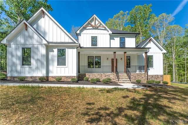 modern inspired farmhouse with a front lawn and covered porch