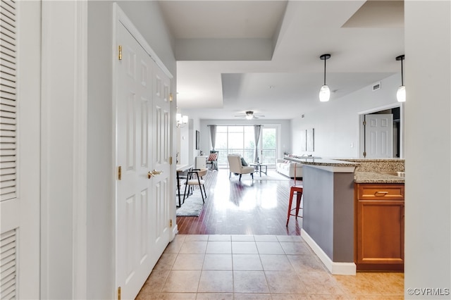 kitchen featuring a kitchen bar, light hardwood / wood-style flooring, and decorative light fixtures