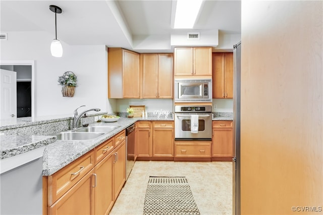 kitchen with light stone counters, sink, hanging light fixtures, appliances with stainless steel finishes, and light tile patterned floors