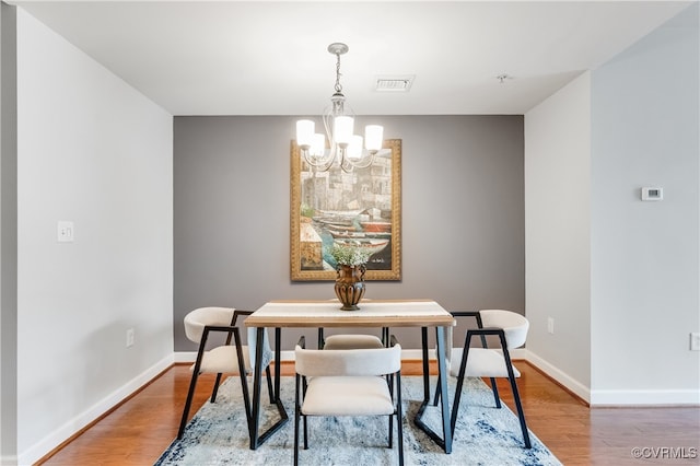 dining area featuring a notable chandelier and wood-type flooring