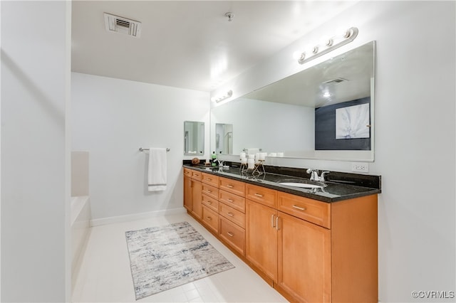 bathroom with vanity, tile patterned flooring, and a bath