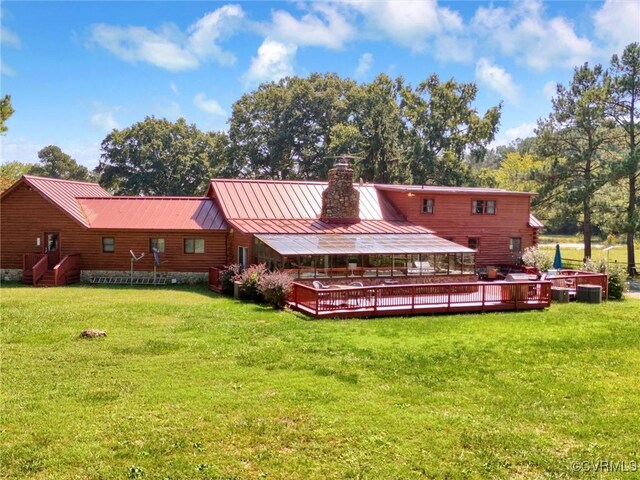 rear view of house featuring a yard and a wooden deck