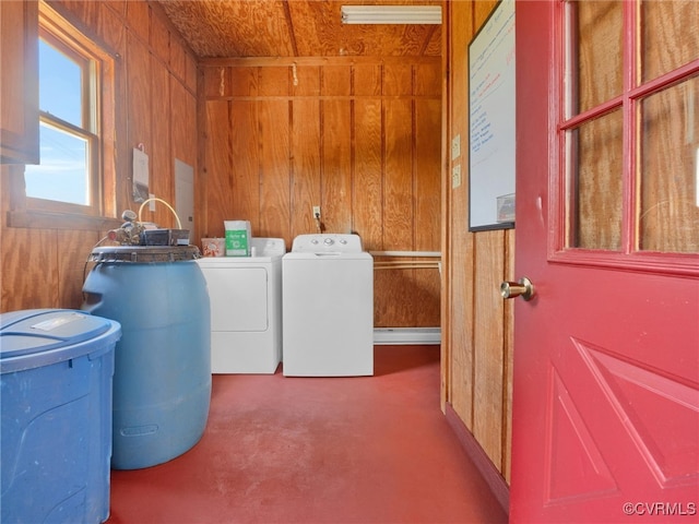 clothes washing area featuring carpet floors, wooden walls, and washing machine and clothes dryer