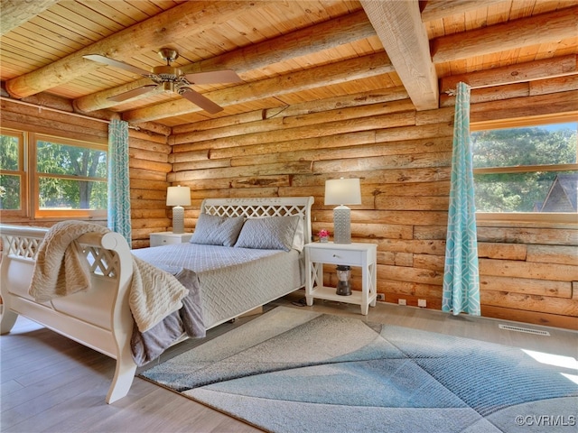 bedroom featuring ceiling fan, hardwood / wood-style flooring, wood ceiling, and rustic walls