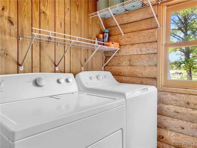 laundry room with log walls and independent washer and dryer