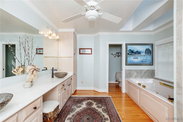 bathroom with vanity, toilet, ornamental molding, and ceiling fan