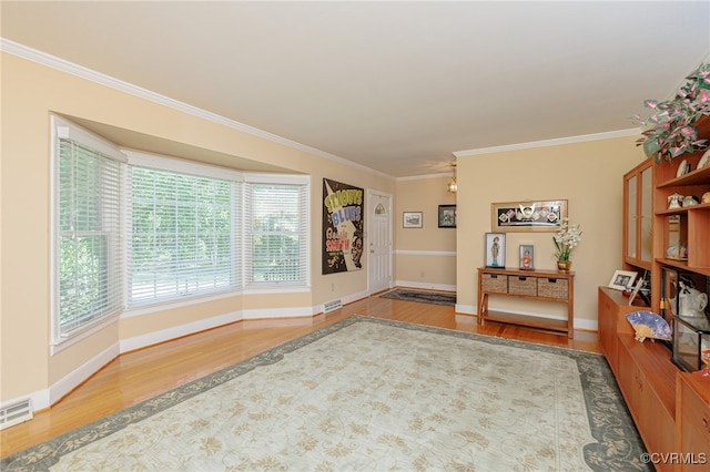 living area with crown molding and hardwood / wood-style flooring