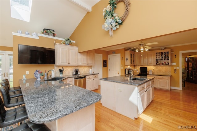 kitchen featuring stainless steel dishwasher, kitchen peninsula, ceiling fan, and a breakfast bar area