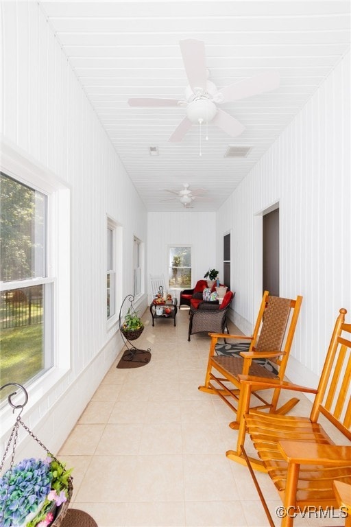 sunroom / solarium featuring ceiling fan