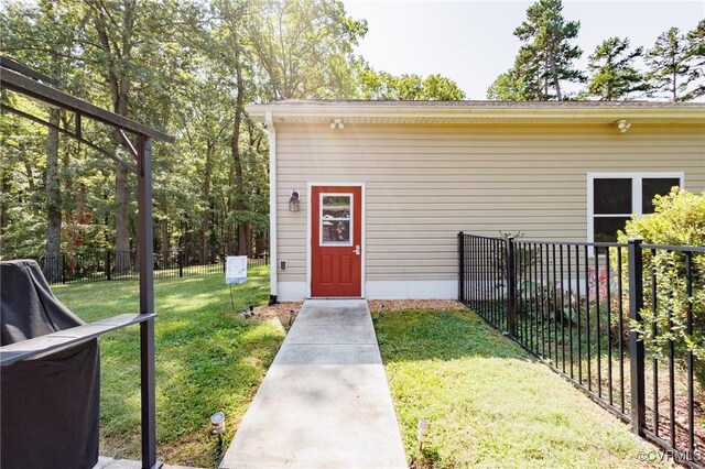 view of exterior entry with a lawn