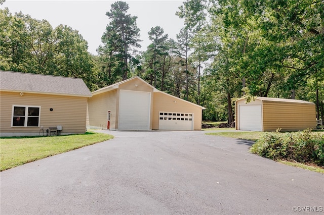 view of front facade with an outbuilding, a front yard, and a garage