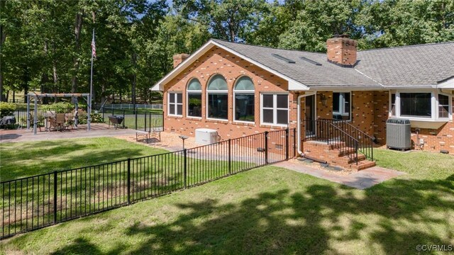 back of property with a lawn, a patio area, and central air condition unit