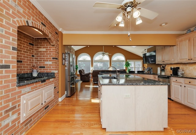 kitchen featuring light brown cabinetry, light wood-type flooring, appliances with stainless steel finishes, ceiling fan, and a kitchen island with sink