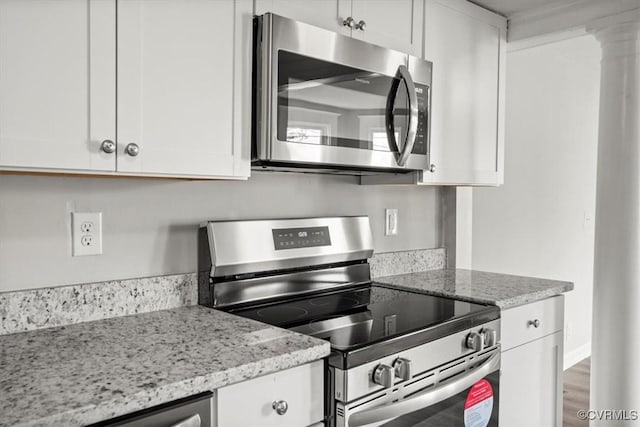 kitchen featuring stainless steel appliances, white cabinetry, hardwood / wood-style floors, and light stone counters