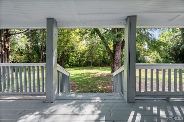 wooden terrace featuring a yard