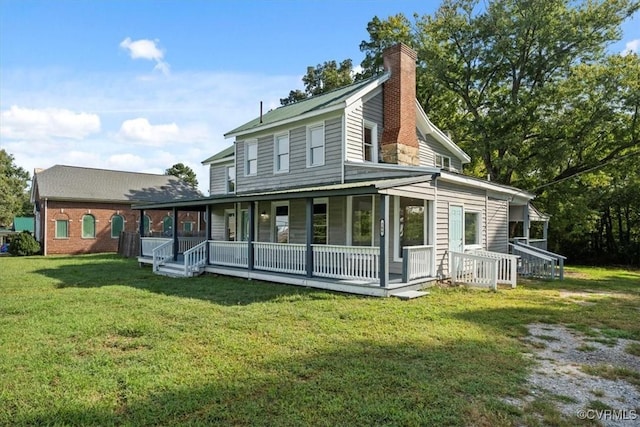 rear view of property featuring a sunroom and a lawn