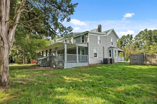 view of home's exterior featuring a porch, a yard, and central AC