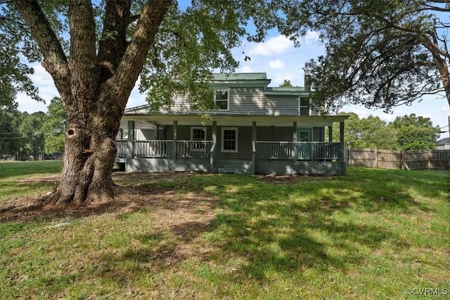 rear view of house featuring a porch and a yard