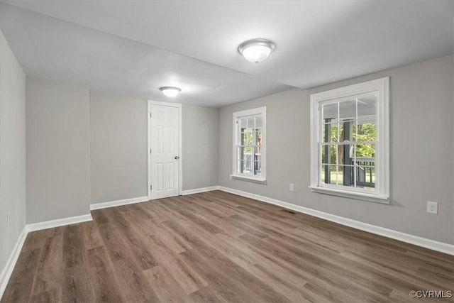 unfurnished room with dark hardwood / wood-style flooring