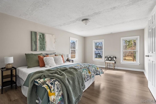 bedroom featuring dark wood-type flooring and a textured ceiling