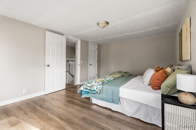 bedroom with wood-type flooring and a textured ceiling