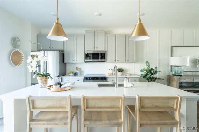 kitchen with a breakfast bar area, hanging light fixtures, and stainless steel appliances