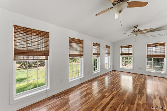 spare room with lofted ceiling, a wall mounted air conditioner, wood-type flooring, and ceiling fan