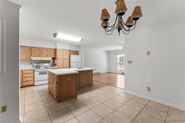 kitchen with light tile patterned floors, a center island, ceiling fan with notable chandelier, white appliances, and sink