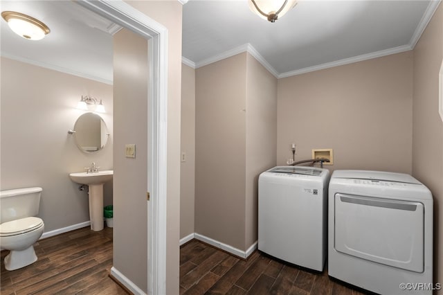 clothes washing area with sink, dark hardwood / wood-style floors, washing machine and clothes dryer, and ornamental molding