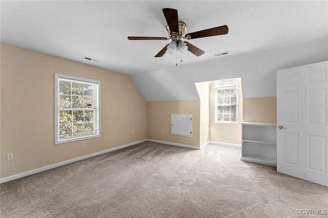 additional living space with light colored carpet, ceiling fan, and lofted ceiling